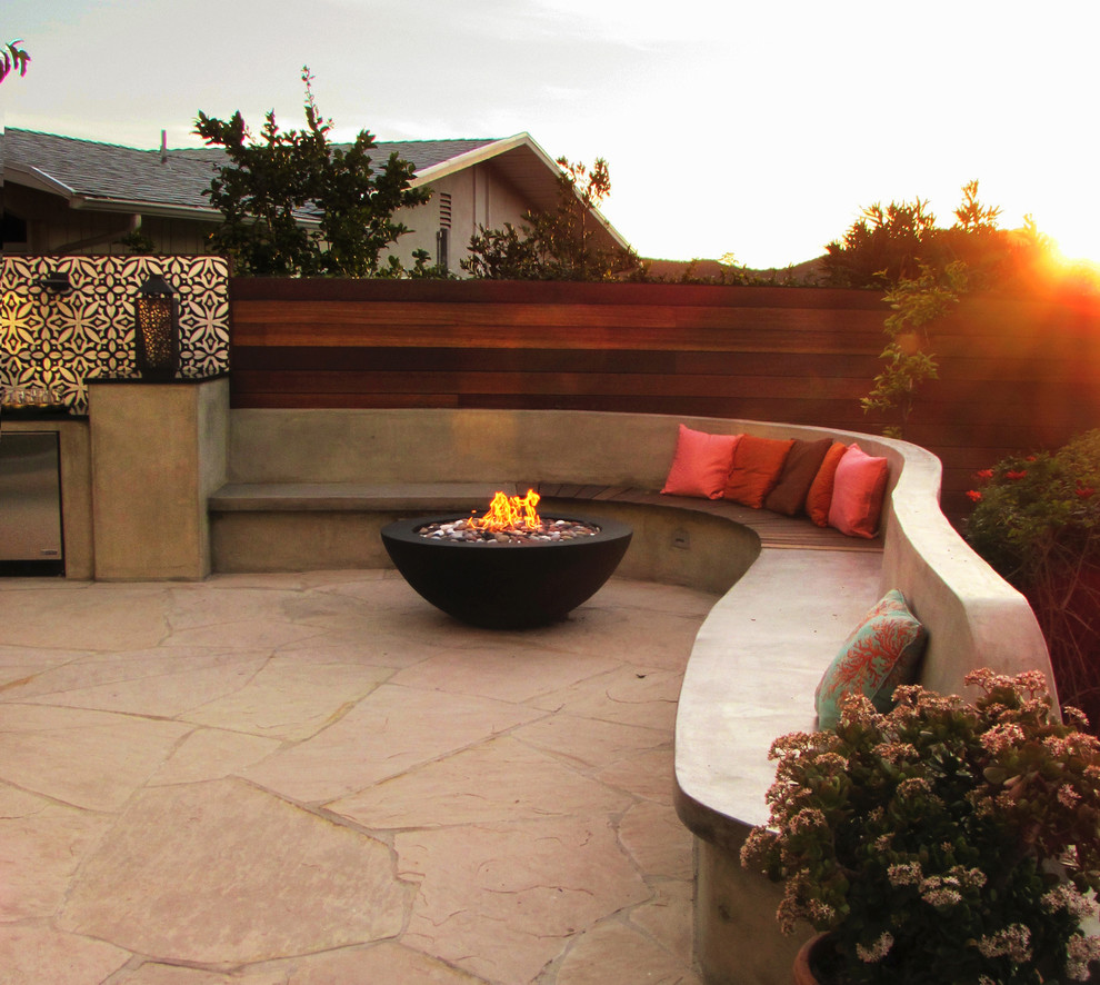 This is an example of a mid-sized contemporary courtyard patio in Los Angeles with natural stone pavers.
