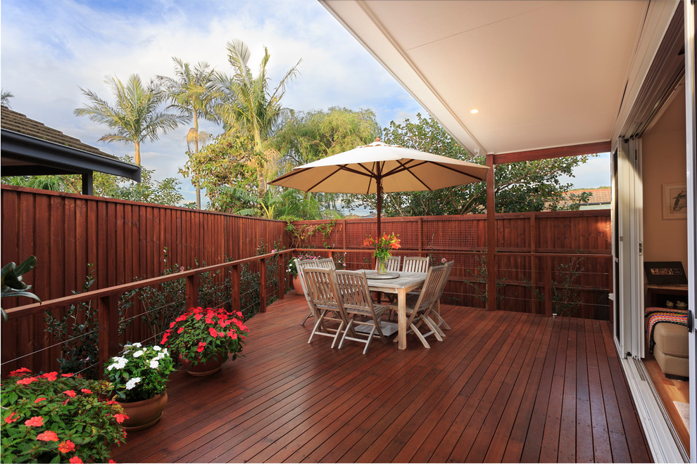 Inspiration for a small contemporary backyard deck in Central Coast with a roof extension.