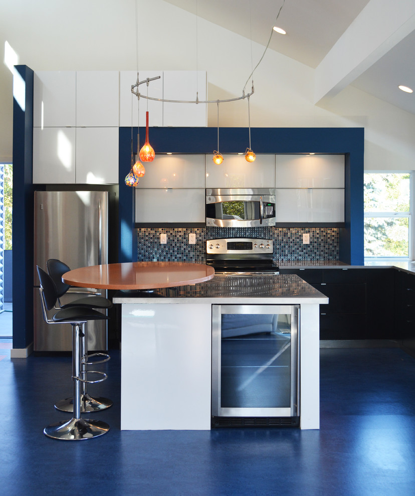 Photo of a mid-sized contemporary l-shaped open plan kitchen in Seattle with an undermount sink, flat-panel cabinets, white cabinets, quartz benchtops, blue splashback, mosaic tile splashback, stainless steel appliances, linoleum floors, with island and blue floor.