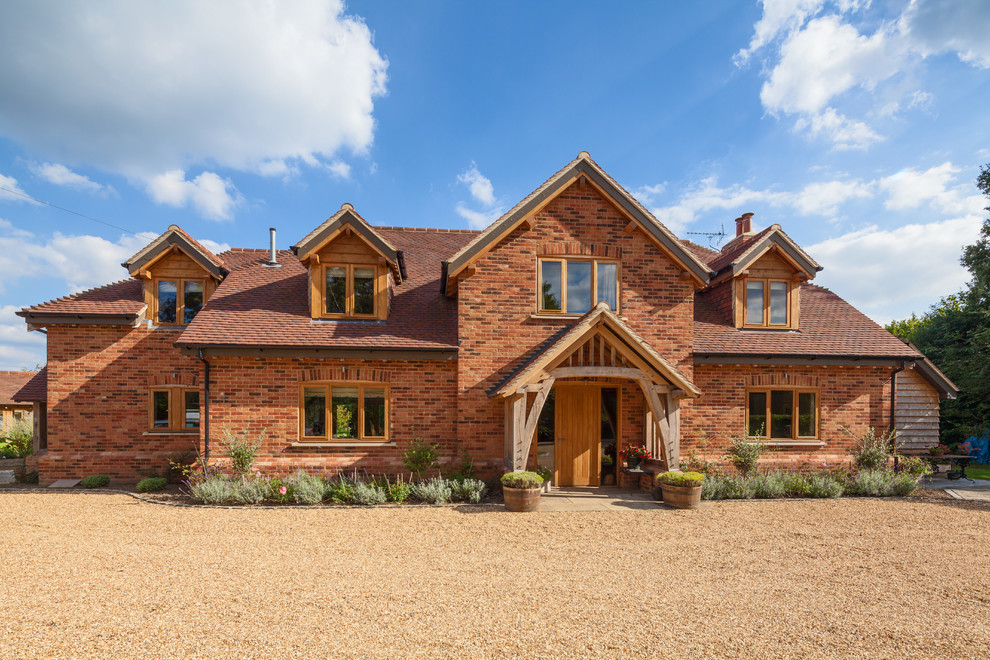 Country two-storey brick multi-coloured house exterior in Surrey with a gable roof and a shingle roof.