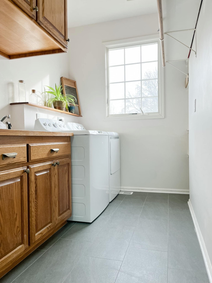 Imagen de cuarto de lavado de galera clásico pequeño con paredes blancas, suelo de baldosas de cerámica, lavadora y secadora juntas y suelo gris