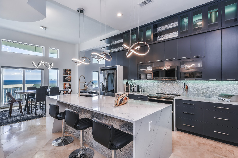 Design ideas for a large contemporary galley eat-in kitchen in Houston with an undermount sink, flat-panel cabinets, black cabinets, grey splashback, matchstick tile splashback, black appliances, with island, beige floor and grey benchtop.
