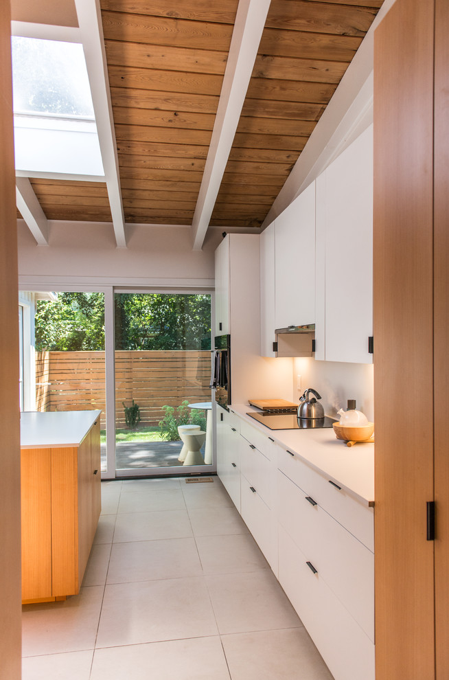 Design ideas for a midcentury kitchen in Atlanta with an undermount sink, medium wood cabinets, solid surface benchtops, white splashback, with island, white floor and white benchtop.