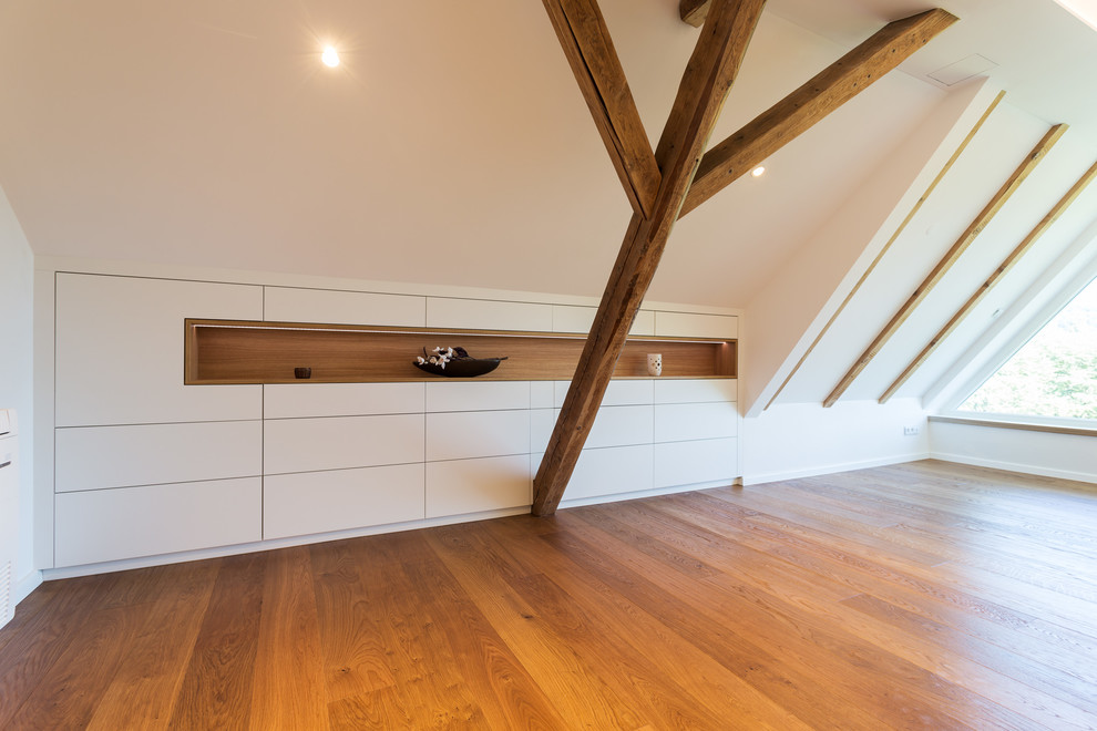 Inspiration pour une chambre parentale minimaliste de taille moyenne avec un mur blanc, un sol en bois brun, un sol marron, poutres apparentes et du papier peint.
