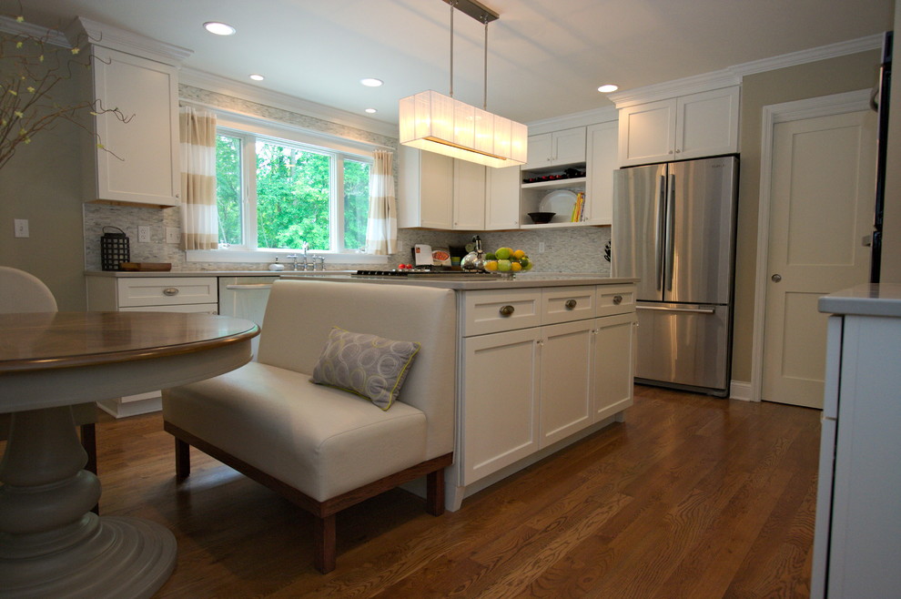 Example of a large transitional medium tone wood floor kitchen design in Cincinnati with an undermount sink, flat-panel cabinets, white cabinets, quartz countertops, gray backsplash, porcelain backsplash, stainless steel appliances and an island