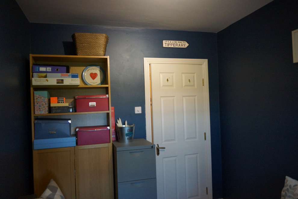 Idee per un piccolo ufficio design con pareti blu, pavimento in laminato, scrivania autoportante e pavimento marrone