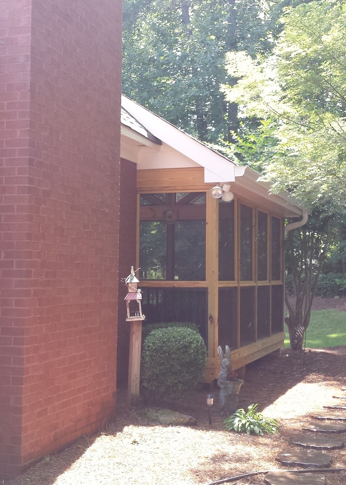 Large traditional side yard screened-in verandah in Atlanta with a roof extension.