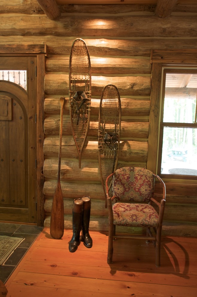 Mid-sized mountain style medium tone wood floor entry hall photo with brown walls and a medium wood front door