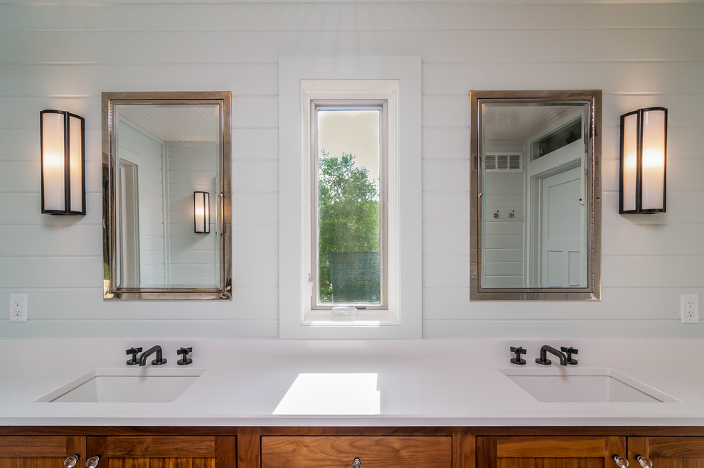 Inspiration for a large transitional master linoleum floor alcove shower remodel with shaker cabinets, medium tone wood cabinets, white walls, an undermount sink, a hinged shower door and solid surface countertops