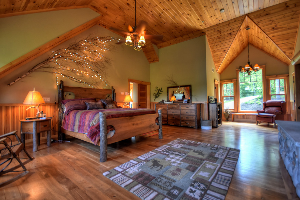 Inspiration for a country bedroom in Boston with green walls, medium hardwood floors, brown floor, vaulted and wood.