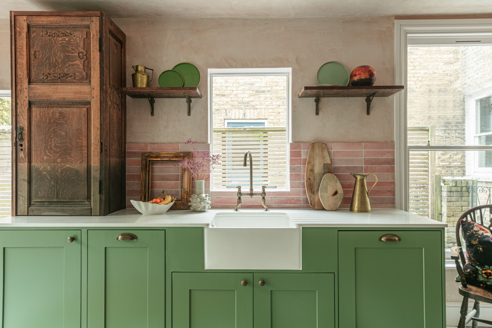 Mid-sized country galley eat-in kitchen in London with a farmhouse sink, shaker cabinets, green cabinets, quartzite benchtops, pink splashback, ceramic splashback, no island, multi-coloured floor and white benchtop.
