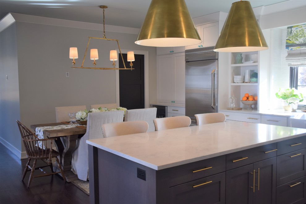 Inspiration for a large transitional dark wood floor eat-in kitchen remodel with a farmhouse sink, shaker cabinets, white cabinets, quartzite countertops, white backsplash, subway tile backsplash, stainless steel appliances and an island