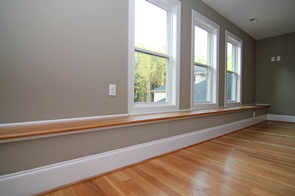 Photo of a large contemporary gender-neutral kids' room in Raleigh with grey walls and light hardwood floors.