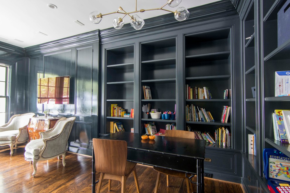 This is an example of a traditional family room in Raleigh with a library, blue walls and dark hardwood floors.