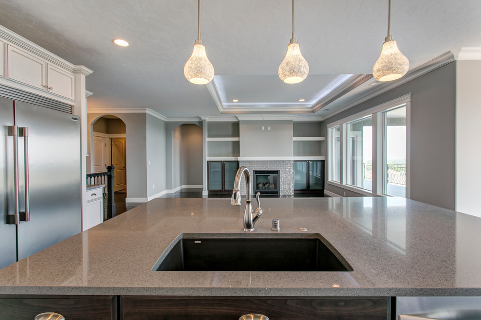 Inspiration for a mid-sized transitional l-shaped dark wood floor open concept kitchen remodel in Seattle with an undermount sink, shaker cabinets, white cabinets, quartz countertops, gray backsplash, glass tile backsplash, stainless steel appliances and an island