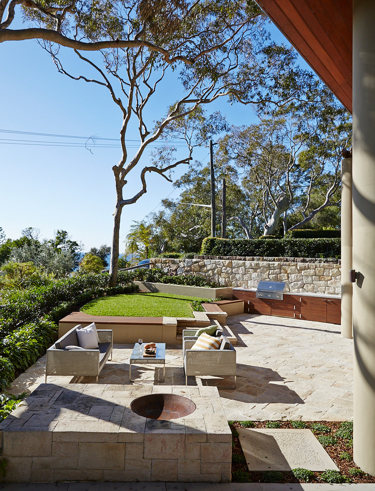 Design ideas for a mid-sized contemporary backyard formal garden for summer in Sydney with natural stone pavers.