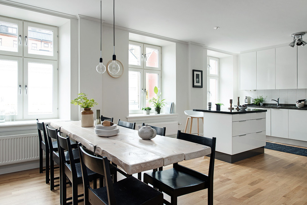Mid-sized scandinavian separate dining room in Gothenburg with white walls, light hardwood floors and no fireplace.