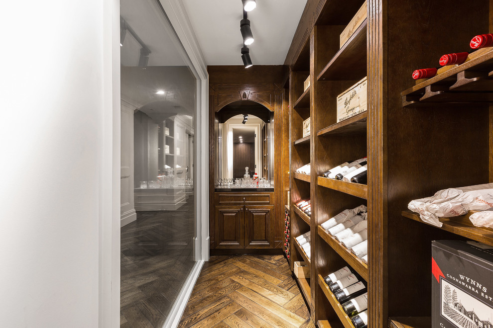Inspiration for a large traditional wine cellar in Melbourne with dark hardwood floors and display racks.