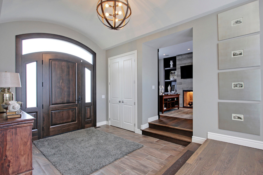 Mid-sized transitional foyer in Calgary with grey walls, ceramic floors, a single front door and a dark wood front door.