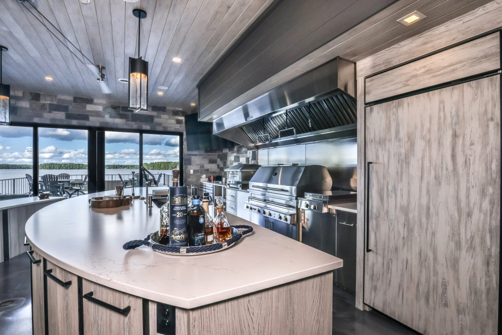 Photo of a modern galley open plan kitchen in Other with an undermount sink, flat-panel cabinets, grey cabinets, solid surface benchtops, limestone splashback, stainless steel appliances, concrete floors, multiple islands, grey floor, white benchtop and recessed.