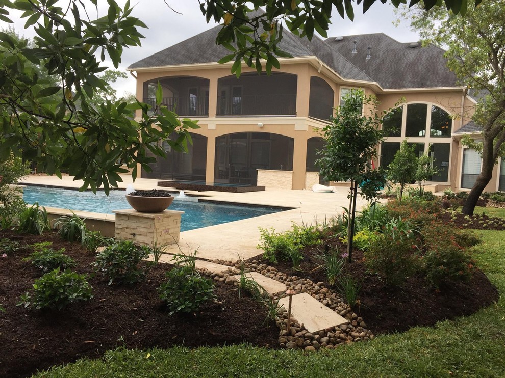 Example of a large transitional backyard concrete paver and rectangular lap pool fountain design in Houston