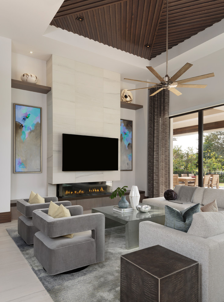 Design ideas for a large modern open concept living room in Miami with white walls, a ribbon fireplace, a wall-mounted tv, porcelain floors, a tile fireplace surround and beige floor.