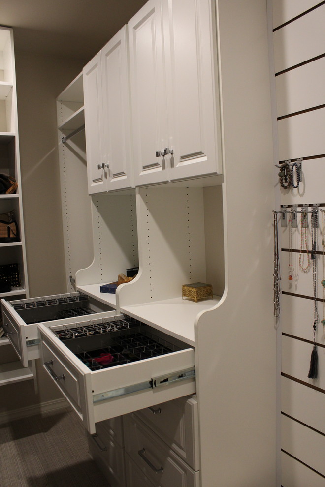 This is an example of a mid-sized modern women's walk-in wardrobe in New Orleans with open cabinets, white cabinets and carpet.