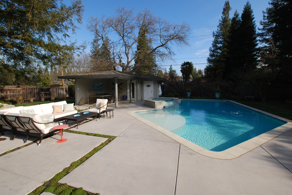 Photo of a large contemporary backyard custom-shaped pool in San Francisco with a hot tub and concrete slab.