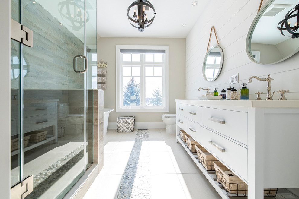 Mid-sized modern master bathroom in Toronto with flat-panel cabinets, white cabinets, engineered quartz benchtops, a freestanding tub, a corner shower, a one-piece toilet, beige walls, an undermount sink and a hinged shower door.