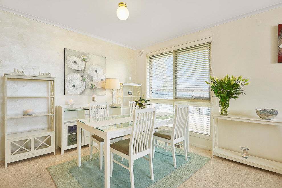 Beach style dining room in Melbourne with beige walls, carpet and no fireplace.