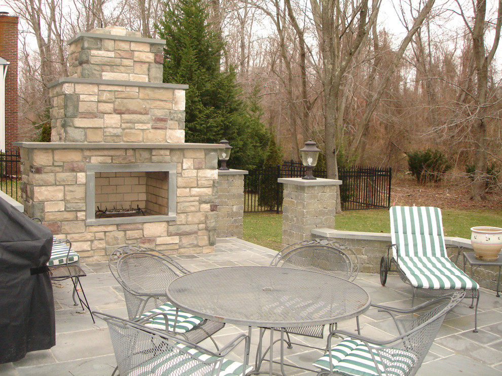 Design ideas for a mid-sized traditional backyard patio in New York with a fire feature, natural stone pavers and no cover.