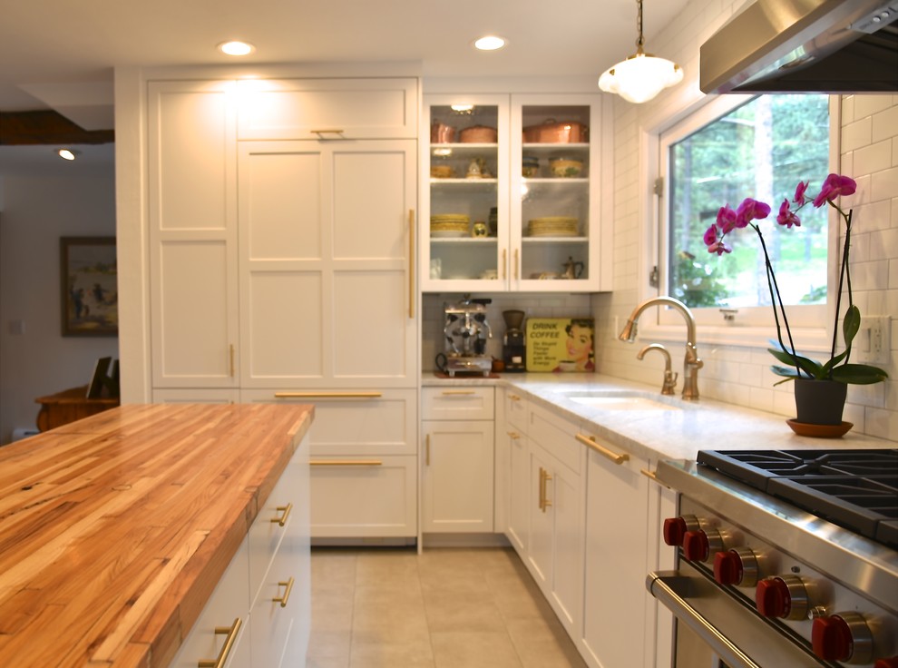 Small traditional u-shaped eat-in kitchen in Denver with a single-bowl sink, shaker cabinets, white cabinets, wood benchtops, white splashback, ceramic splashback, stainless steel appliances, porcelain floors, with island, grey floor and white benchtop.