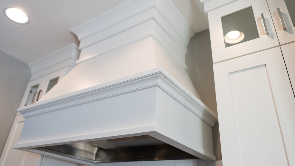 Inspiration for a large transitional u-shaped eat-in kitchen remodel with a farmhouse sink, flat-panel cabinets, white cabinets, granite countertops, white backsplash, ceramic backsplash, stainless steel appliances and an island