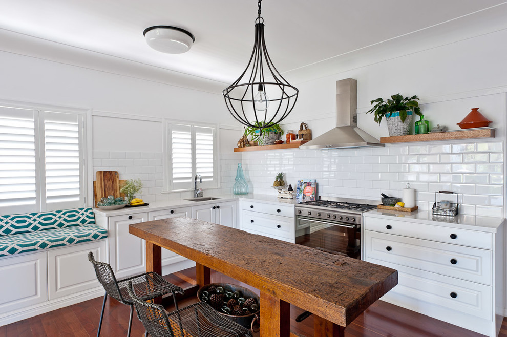 Mid-sized country l-shaped eat-in kitchen in Brisbane with an undermount sink, raised-panel cabinets, white cabinets, granite benchtops, white splashback, subway tile splashback, stainless steel appliances, dark hardwood floors and with island.