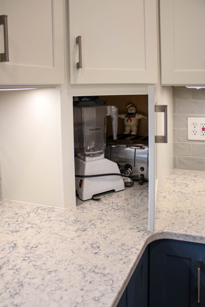 Mid-sized transitional galley kitchen pantry in Cleveland with a farmhouse sink, flat-panel cabinets, blue cabinets, quartz benchtops, grey splashback, ceramic splashback, white appliances, porcelain floors, no island, brown floor and white benchtop.