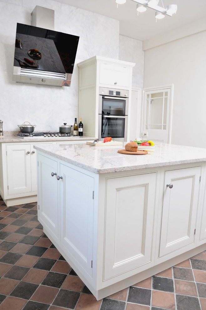 This is an example of a transitional l-shaped eat-in kitchen in Other with a double-bowl sink, beaded inset cabinets, granite benchtops, white splashback and stainless steel appliances.