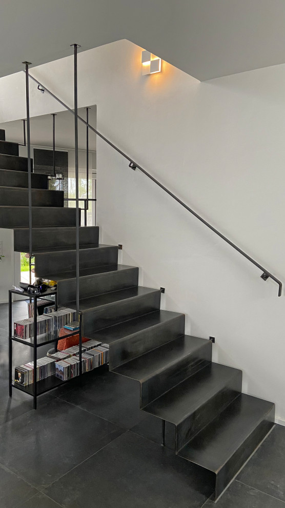 Diseño de escalera recta industrial de tamaño medio con escalones de metal, contrahuellas de metal y barandilla de metal