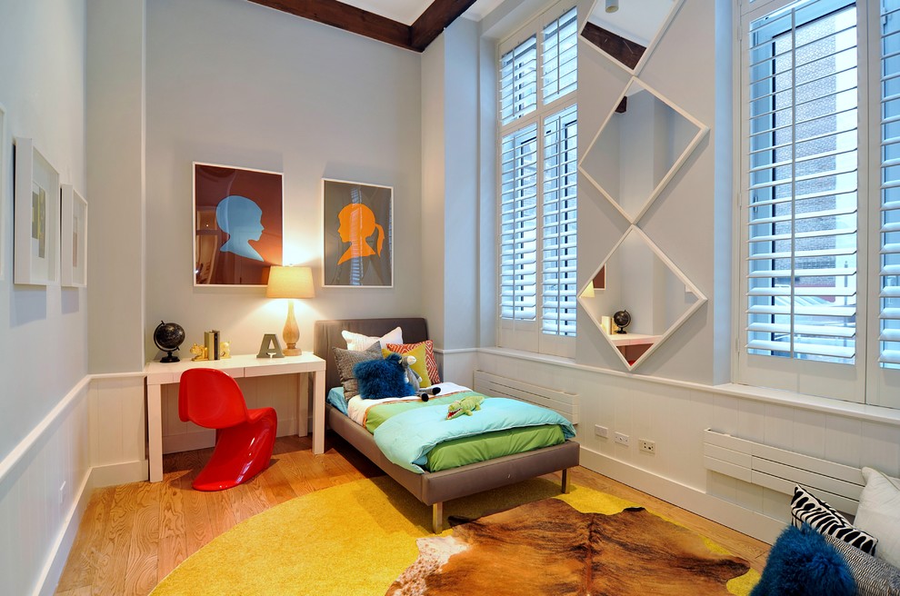 Contemporary gender-neutral kids' bedroom in New York with grey walls and medium hardwood floors for kids 4-10 years old.