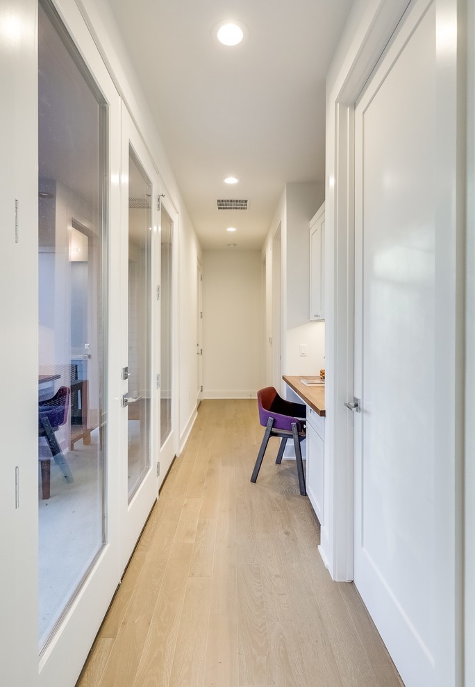 This is an example of a mid-sized midcentury hallway in Austin with beige walls, dark hardwood floors and brown floor.