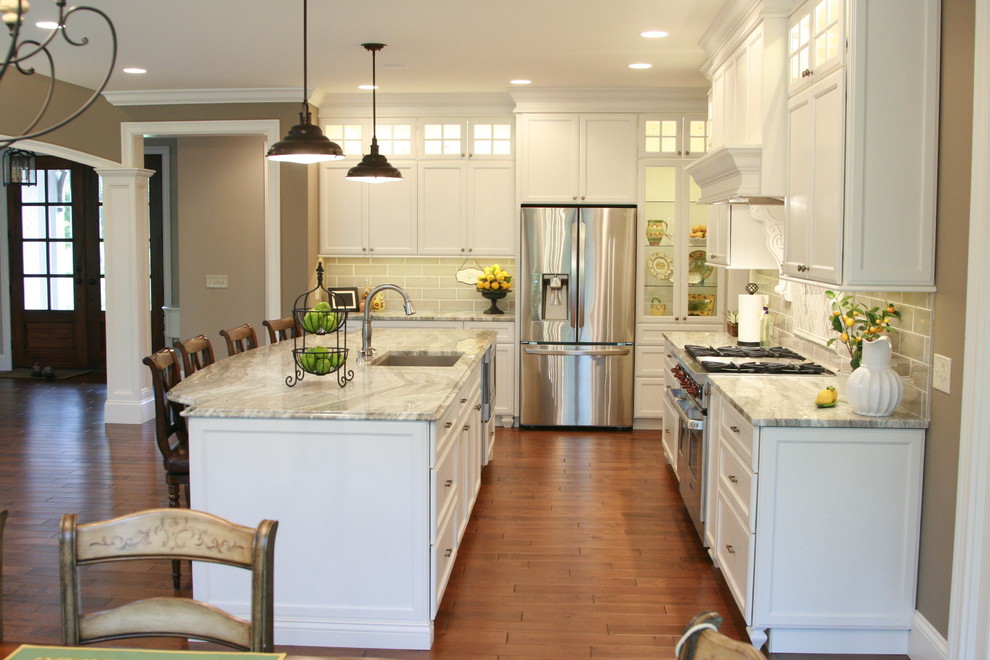 Example of a large transitional l-shaped medium tone wood floor open concept kitchen design in Cincinnati with an undermount sink, flat-panel cabinets, white cabinets, granite countertops, gray backsplash, subway tile backsplash, stainless steel appliances and an island