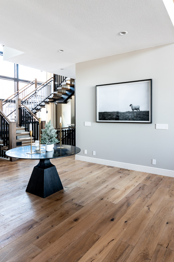 Large transitional medium tone wood floor, brown floor and shiplap wall foyer photo in Calgary with white walls and a black front door
