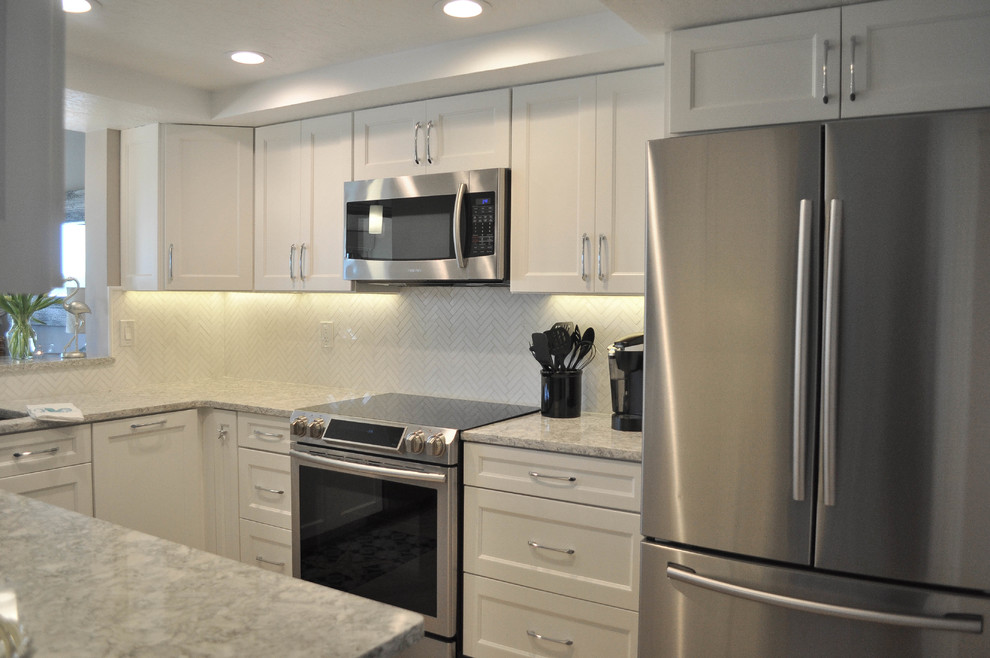 Eat-in kitchen - mid-sized transitional u-shaped eat-in kitchen idea with an undermount sink, shaker cabinets, white cabinets, quartz countertops, white backsplash, marble backsplash, stainless steel appliances and no island