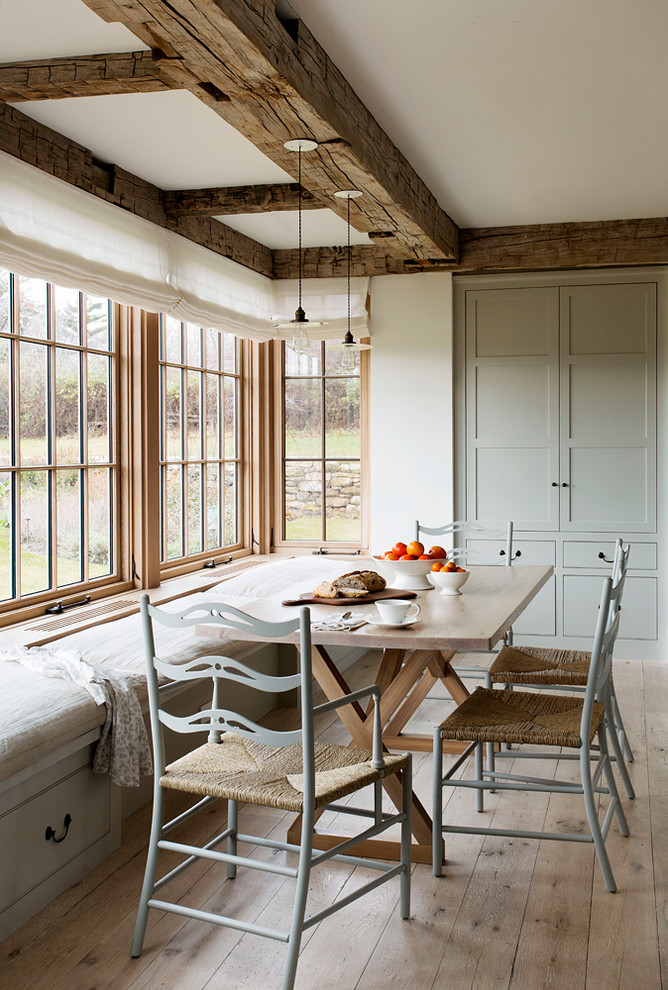 Inspiration for a mid-sized country eat-in kitchen in Denver with blue cabinets and light hardwood floors.