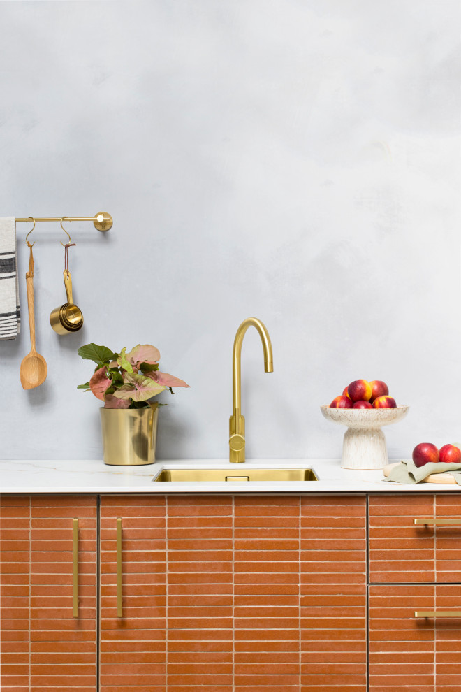 Immagine di una piccola cucina moderna con lavello a vasca singola, ante lisce, ante arancioni, top in marmo, paraspruzzi grigio, paraspruzzi in lastra di pietra e top grigio