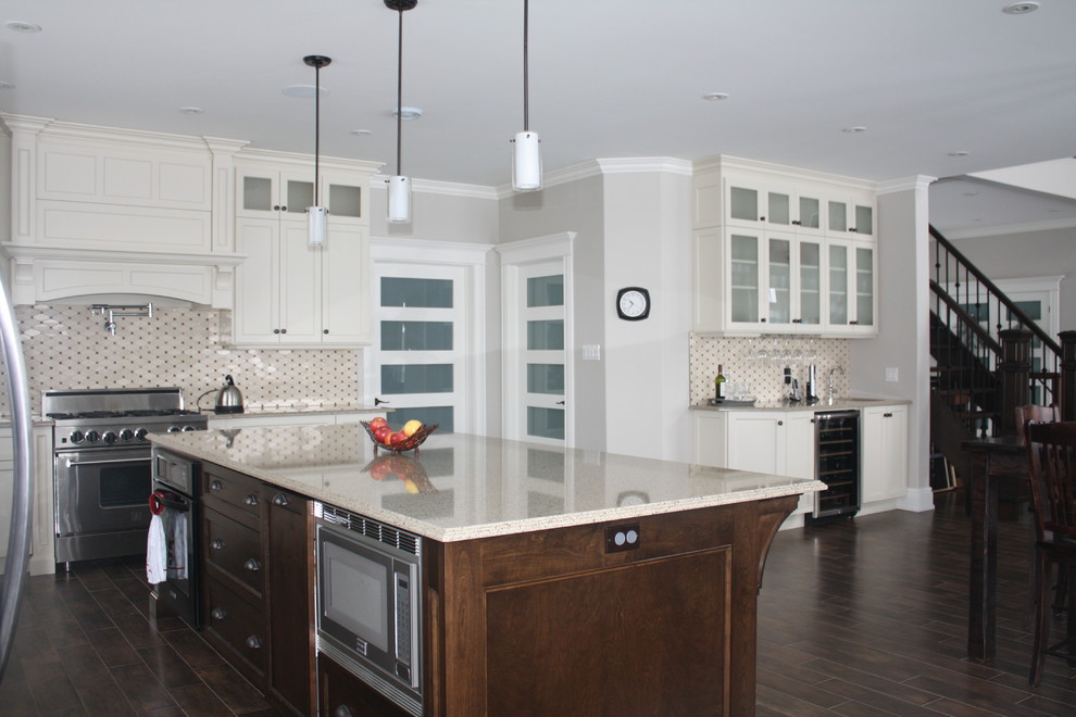 Inspiration for a large timeless l-shaped medium tone wood floor eat-in kitchen remodel with an island, recessed-panel cabinets, yellow cabinets, quartz countertops, black backsplash, cement tile backsplash, stainless steel appliances and a farmhouse sink