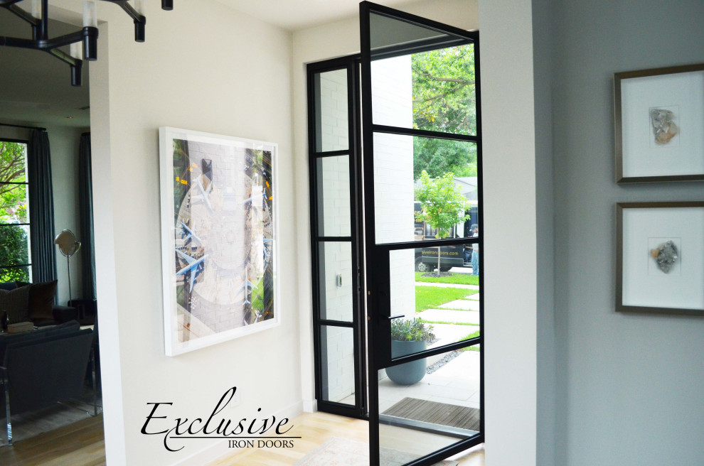 This is an example of a medium sized contemporary front door in Austin with white walls, a single front door and a black front door.