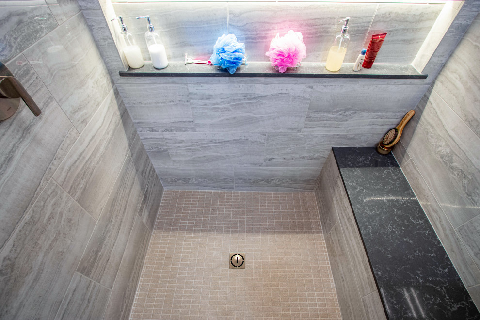 Стильный дизайн: большая главная ванная комната в стиле неоклассика (современная классика) с белыми фасадами, гидромассажной ванной, угловым душем, бежевой плиткой, серыми стенами, полом из керамической плитки, врезной раковиной, столешницей из искусственного кварца, серым полом, душем с распашными дверями, серой столешницей, нишей, тумбой под одну раковину и встроенной тумбой - последний тренд