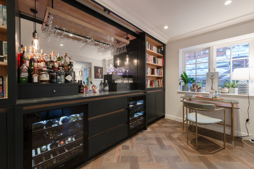 Cette image montre un bar de salon sans évier parallèle design de taille moyenne avec un placard à porte shaker, des portes de placard noires et un sol en bois brun.