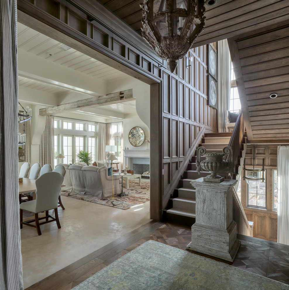 This is an example of a large beach style foyer in Other with brown walls, painted wood floors, brown floor, wood and wood walls.
