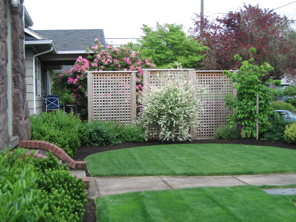 This is an example of a mid-sized traditional front yard full sun garden for summer in Portland with a garden path.